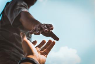 two hands reaching out for each other